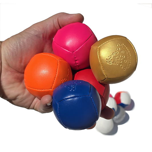 Hand holding a collection of colorful leather balls on a white background